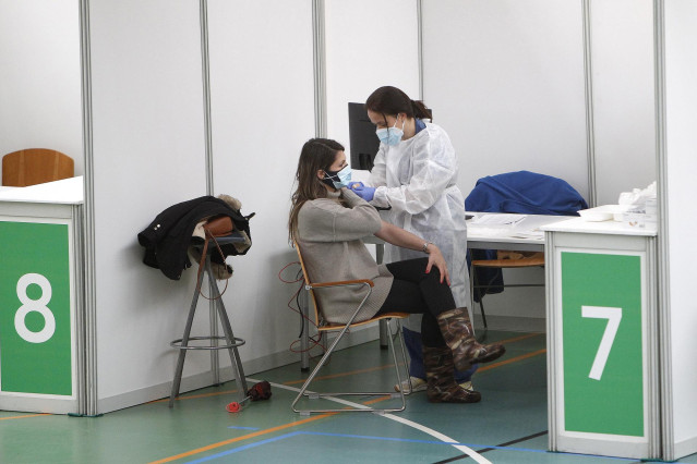 Archivo - Un empleada sanitaria suministra la vacuna contra la Covid-19.