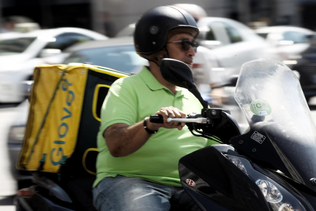 Archivo - Un repartidor de la empresa de reparto de comida a domicilio Glovo, circula en moto por una calle de Madrid
