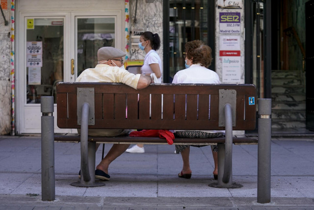 Archivo - Una pareja de ancianos con mascarilla sentada en un banco, a 27 de julio de 2021, en Madrid, (España).