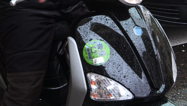 Archivo - Una moto con un distintivo ambiental de la Dirección General de Tráfico (DGT) de tipo C, pegado sobre uno de los faros.