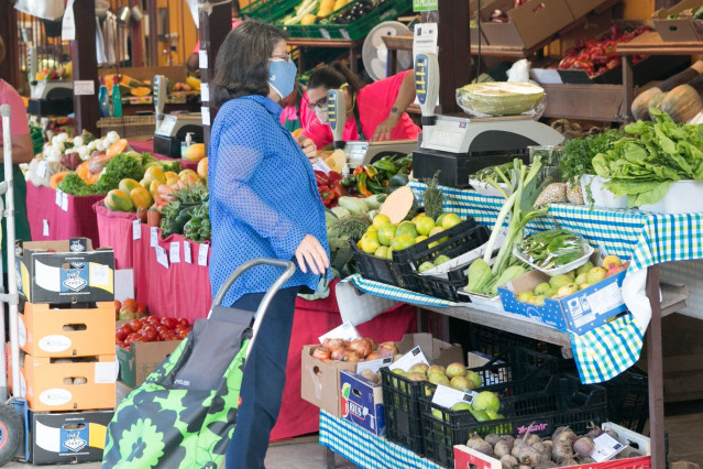 Archivo - Una mujer comprando en un mercado