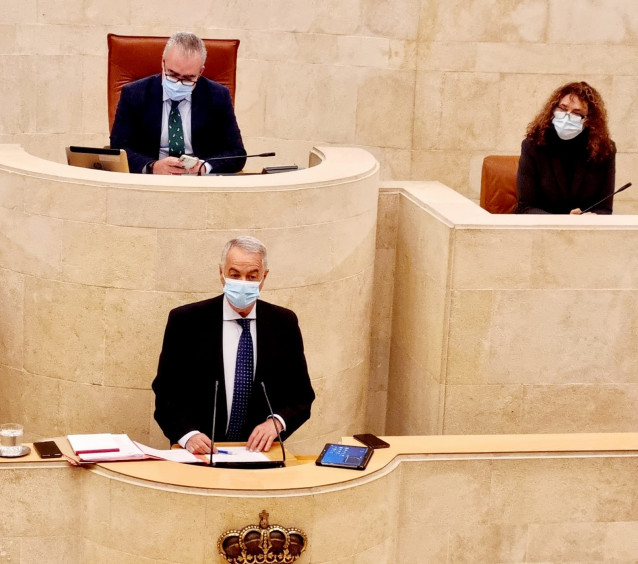 En la tribuna, de pie, el presidente de la Asociación 11M Afectados del Terrorismo, Eulogio Paz, comparece en el Parlamento de Cantabria