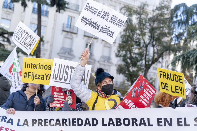 Un grupo de personas con carteles durante una manifestación de interinos frente al Congreso