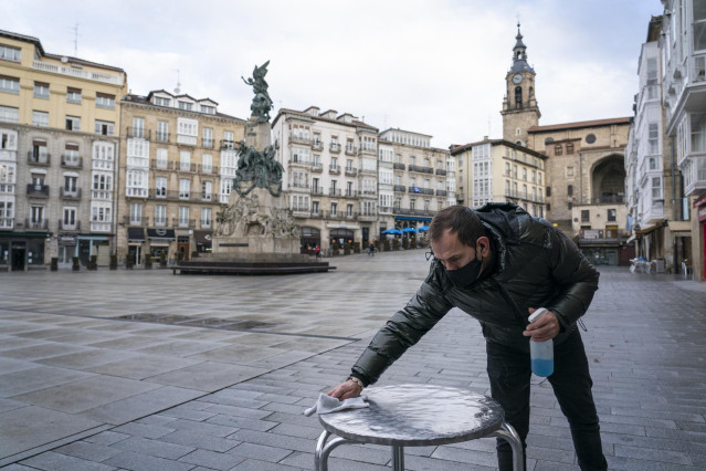 Archivo - Un camarero limpia una mesa de la terraza de su cafetería durante una jornada marcada por la reapertura de los establecimientos en los municipios vascos pertenecientes a la ‘zona roja’, en Vitoria, Álava, País Vasco, (España), a 10 de febrero de