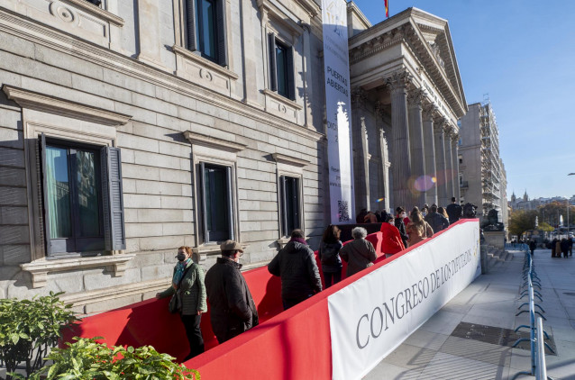 Varios personas hacen cola en las inmediaciones del Congreso de los Diputados para entrar a visitarlo, el día de la inauguración de las jornadas de Puertas Abiertas en la Cámara Baja, a 3 de diciembre de 2021, en Madrid (España). La Puerta de los Leones d