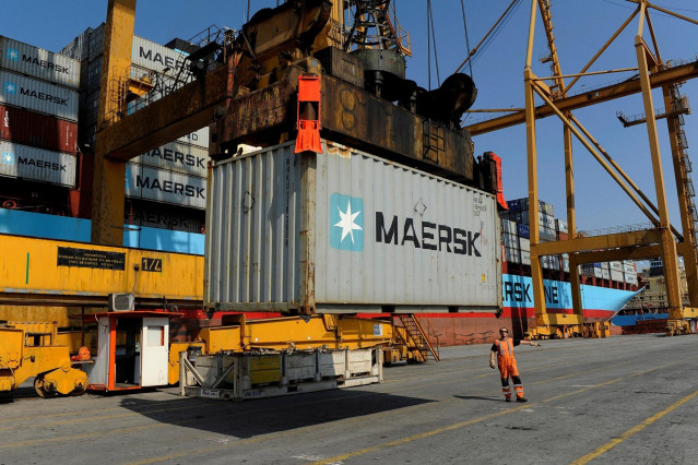 Archivo - A port worker gives directions as a container is prepared to be loaded on a cargo ship at the commercial terminal of the port of the northern city of Thessaloniki