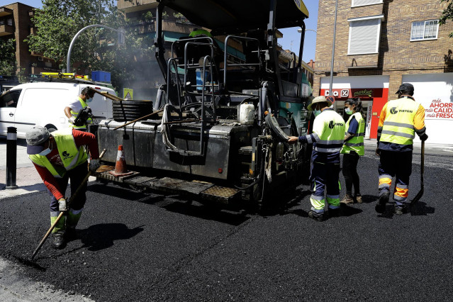 Archivo - Varios operarios trabajan en la renovación del pavimento de una calle de Madrid