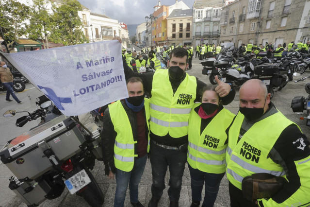 Cuatro personas posan junto a una pancarta donde se lee 