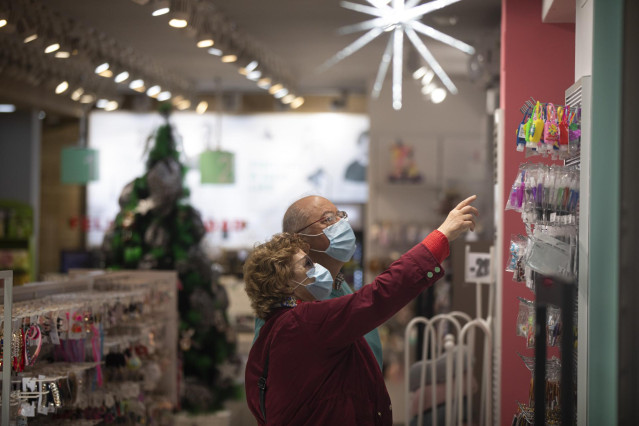 Archivo - Dos personas compran en una tienda ya decorada con motivos navideños. En Sevilla , (Andalucía, España), a 17 de noviembre de 2020.