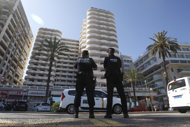 Archivo - Dos policías locales hacen guardia frente al hotel Palma Bellver, donde estaban confinados 249 jóvenes que han tenido relación directa o indirecta con el brote de un viaje de estudios a Mallorca.