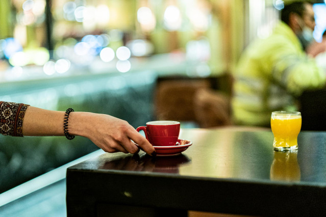 Archivo - Una trabajadora lleva un café en un local de Vitoria, Álava