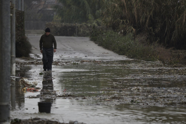 Un hombre camina por una de las carreteras afectadas por la crecida del río Ebro, a 14 de diciembre de 2021, en Buñuel.