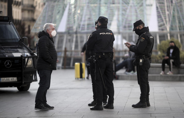 Archivo - Un hombre habla con varios policías nacionales en la Puerta del Sol, en Madrid (España)