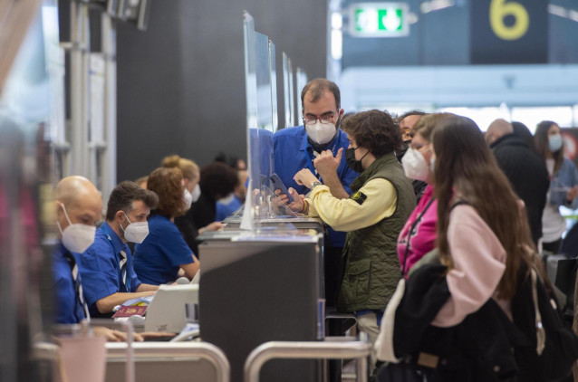 Archivo - Pasajeros esperan para facturar su maleta en la T4 del Aeropuerto Madrid-Barajas