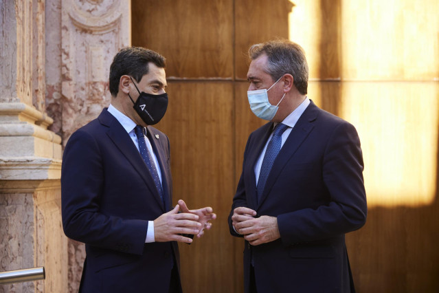 El presidente de la Junta, Juanma Moreno, dialoga con el secretario general del PSOE-A, Juan Espadas, tras su elección como senador autonómico en el Parlamento de Andalucía, en una imagen de 15 de diciembre.