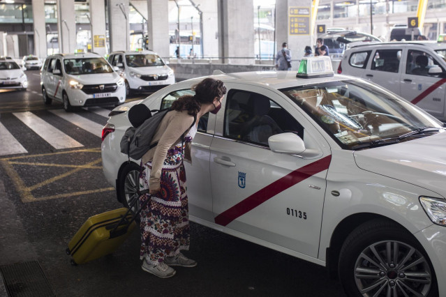 Archivo - Una pasajera conversa con un taxista en las inmediaciones de la Terminal T4  del Aeropuerto Adolfo Suárez Madrid-Barajas, a 7 de junio de 2021, en Madrid, (España). España permite desde este lunes la entrada de viajeros que acrediten estar vacun