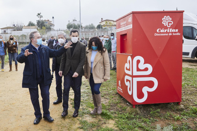 El presidente de la Junta, Juanma Moreno, este lunes junto al presidente de Cáritas Sevilla, Mariano Pérez de Ayala, la consejera de Igualdad, Rocío Ruiz, y detrás de ellos, el alcalde de Dos Hermanas, Francisco Toscano.