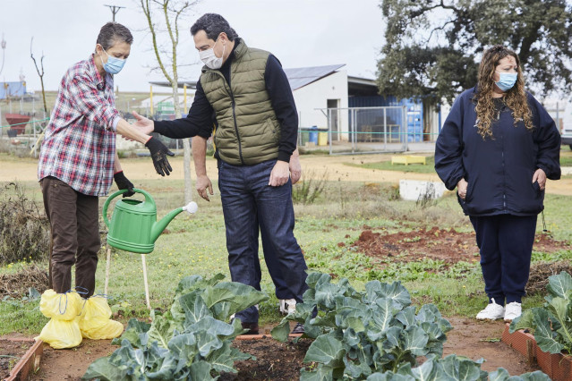 El presidente de la Junta, Juanma Moreno, saluda a los trabajadores en su visita a la empresa de inserción sociolaboral Bioalverde, impulsada por Cáritas en Dos Hermanas (Sevilla)