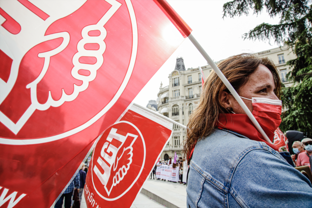 Archivo - Una mujer sostiene una pancarta de UGT en una imagen de archivo.