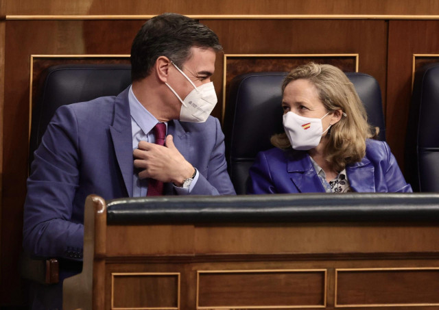 El presidente del Gobierno, Pedro Sánchez, y la vicepresidenta primera del Gobierno y ministra de Asuntos Económicos y Transformación Digital, Nadia Calviño, conversan en una sesión plenaria en el Congreso