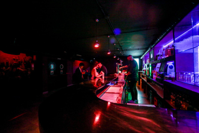 Archivo - Varias personas en la barra de una discoteca de Madrid