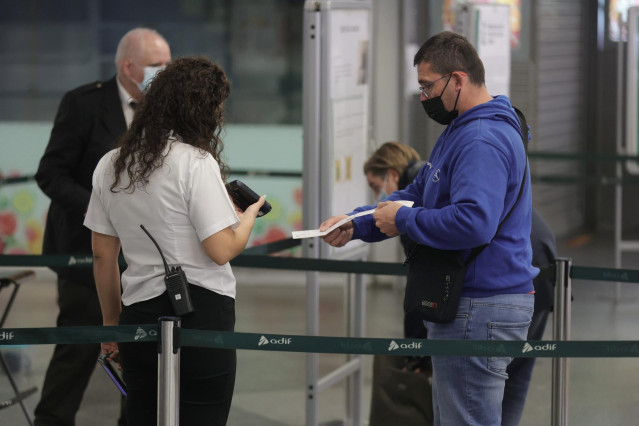 Archivo - Un pasajero pasa su billete por el control para acceder a un tren en la estación de Atocha