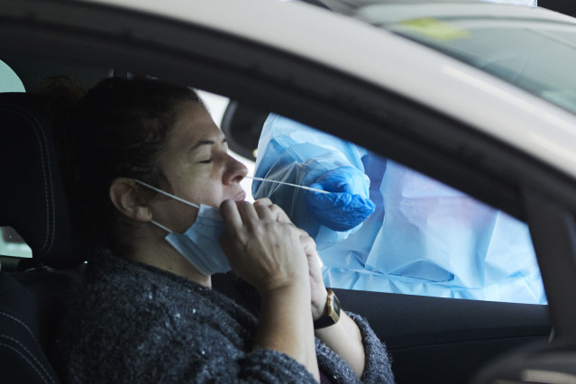 Una sanitaria le realiza la prueba PCR a una mujer en su coche.