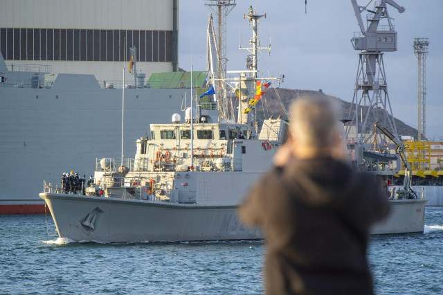 Una persona observa el cazaminas Sella zarpar del puerto de Cartagena para integrarse en la  Snmcmg 2 de la OTAN