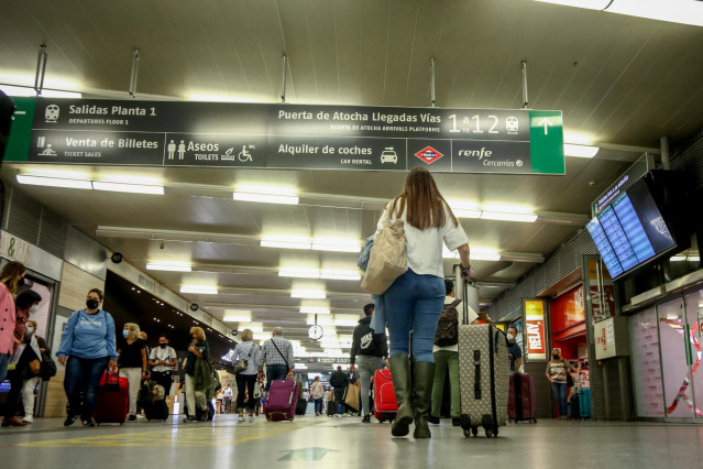 Archivo - Una mujer camina con su equipaje en la estación de Madrid-Puerta de Atocha.