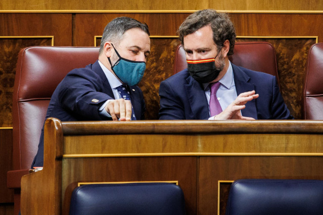 El portavoz de Vox en el Congreso, Iván Espinosa de los Monteros (d), y el presidente de Vox, Santiago Abascal (i), conversan en una sesión plenaria, en el Congreso de los Diputados, a 1 de febrero de 2022, en Madrid (España).