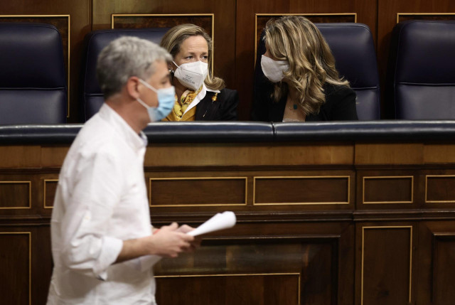 El diputado de EH Bildu, Oskar Matute, pasa por delante de la vicepresidenta de Asuntos Económicos, Nadia Calviño (i); la vicepresidenta segunda del Gobierno y ministra de Trabajo y Economía Social, Yolanda Díaz, en una sesión plenaria en el Congreso