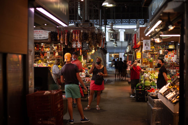 Archivo - Una mujer hace una foto a un joven en el mercado de La Boquería, a 5 de agosto de 2021, en Barcelona.