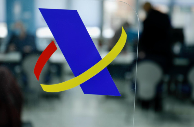 Logotipo de la Agencia Tributaria en una mampara en una Oficina de dicha agencia.