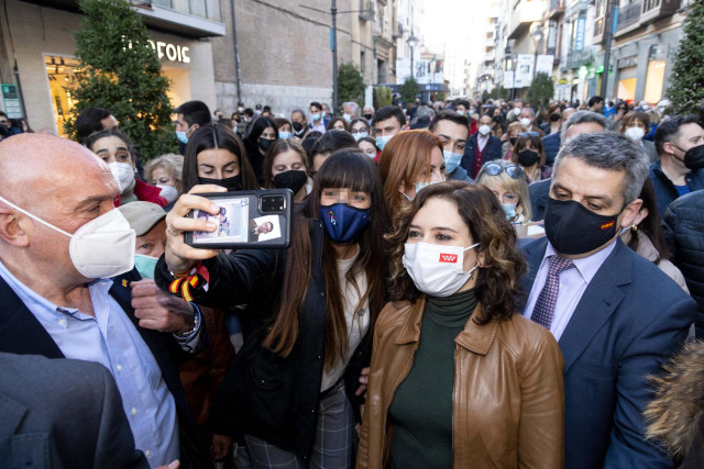 La presidenta de la Comunidad de Madrid, Isabel Díaz Ayuso, se hace una foto con un simpatizante a su llegada a la caseta de campaña del PP, a 8 de febrero de 2022, en Valladolid, Castilla y León (España).