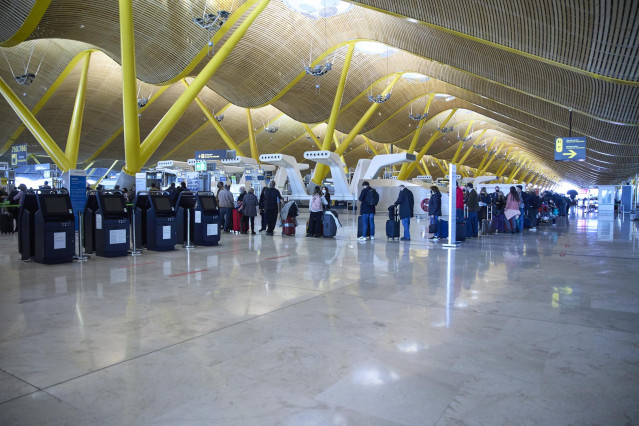 Archivo - Varias personas hacen cola en el aeropuerto Adolfo Suárez.