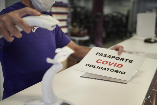 Archivo - Un trabajador escanea el pasaporte Covid a una usuaria, en su gimnasio, Altafit, el día en que han entrado en vigor nuevas restricciones por el coronavirus, a 29 de diciembre, en Pamplona, Navarra, (España). Desde hoy Navarra se convierte en una