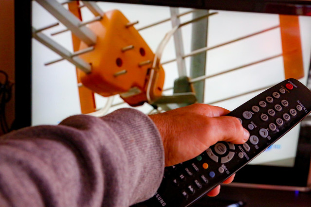 Archivo - Una persona utiliza su mando de la televisión para buscar canales, en Madrid (España), a 7 de octubre de 2020.