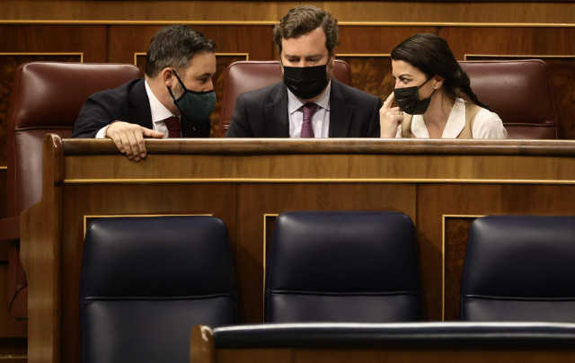 (I-D) El presidente de Vox, Santiago Abascal; el portavoz parlamentario de Vox, Iván Espinosa de los Monteros, y la secretaria general de Vox en el Congreso, Macarena Olona, conversan en una sesión plenaria, en el Congreso de los Diputados