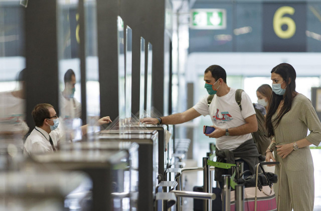 Archivo - Pasajeros con sus maletas en las instalaciones de la Terminal T4 del Aeropuerto Adolfo Suárez Madrid-Barajas.