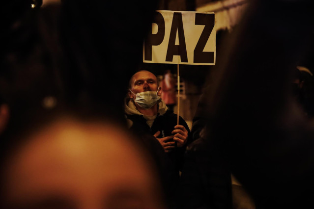 Una persona sostiene una pancarta en una concentración ante la embajada rusa en Madrid tras los primeros ataques rusos registrados en Ucrania esta pasada madrugada, a 24 de febrero de 2022, en Madrid (España).