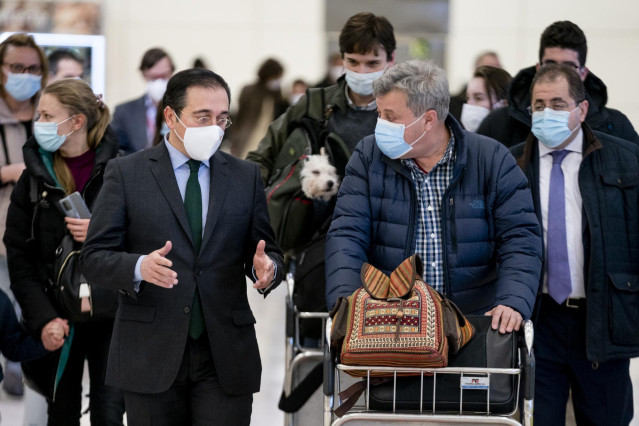 El ministro de Asuntos Exteriores, Unión Europea y Cooperación, José Manuel Albares (i), conversa con varios españoles repatriados a su llegada al Aeropuerto Adolfo Suárez Madrid Barajas, a 28 de febrero de 2022, en Madrid (España).