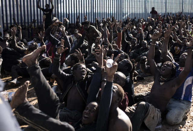 Unos 500 migrantes hacen el signo de la victoria tras saltar la valla de Melilla, a 2 de marzo de 2022, en Melilla (España).