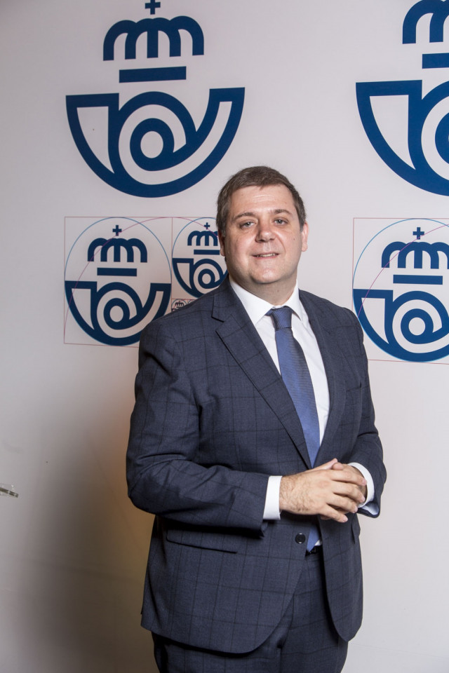 Archivo - El presidente de Correos, Juan Manuel Serrano, con el nuevo logotipo de la compañía