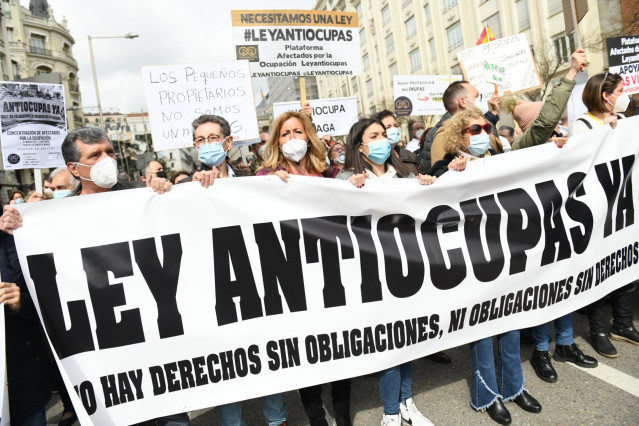 Varias personas con una pancarta que reza 'Ley Antiocupas ya', en la concentración en apoyo a los afectados por la okupación, a 27 de marzo de 2022, en Madrid (España).
