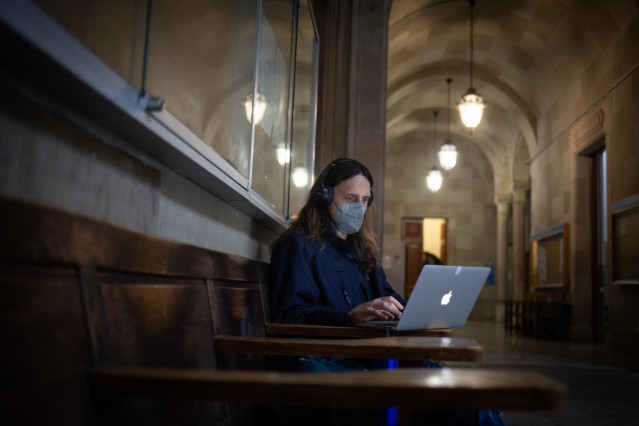 Archivo - Una mujer con un ordenador portátil en la Facultad de Filología y Comunicación Universidad de Barcelona, el edificio central de la Universidad de Barcelona, el primer día de clase presencial tras la Navidad, en la plaza Universitat.