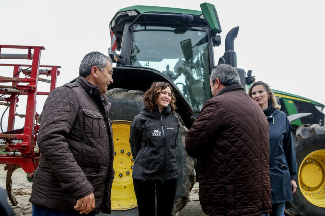 Archivo - La presidenta de la Comunidad de Madrid, Isabel Díaz Ayuso, conversa con los dueños de la explotación Agropecuaria El Espino