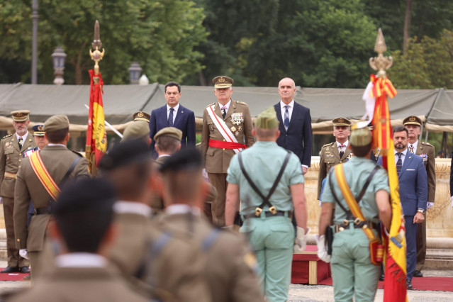 El presidente de la Junta de Andalucía, Juanma Moreno, (i) junto al teniente general de la Fuerza Terrestre , José Rodríguez García, (2d) y el Alcalde de Sevilla, Antonio Muñoz, (d) durante el acto de Jura de Bandera civil en la Plaza de España, a 21 de m