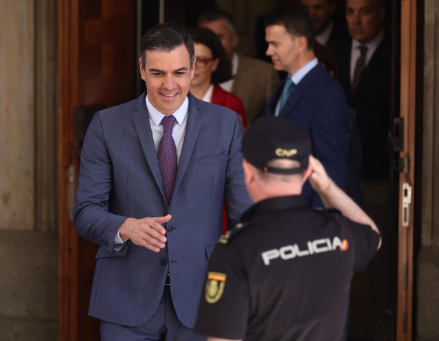 Un agente de Policía Nacional saluda al presidente del Gobierno, Pedro Sánchez, a su salida de una reunión con los diputados y senadores del PSOE, en el Congreso de los Diputados, a 1 de junio de 2022, en Madrid (España).