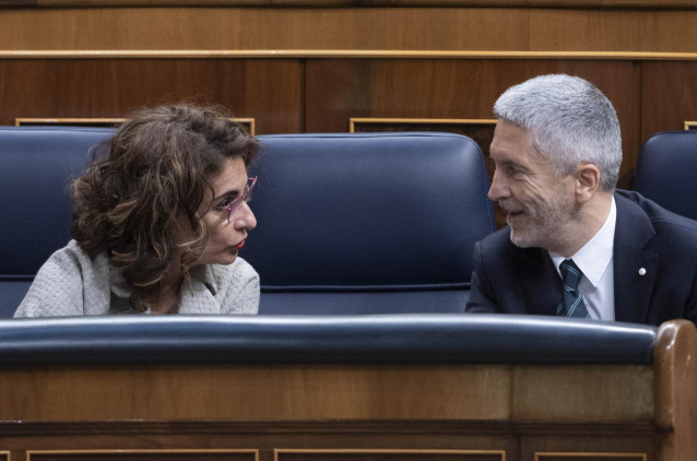 La ministra de Hacienda y Función Pública, María Jesús Montero, conversa con el ministro del Interior, Fernando Grande-Marlaska, durante una sesión plenaria en el Congreso