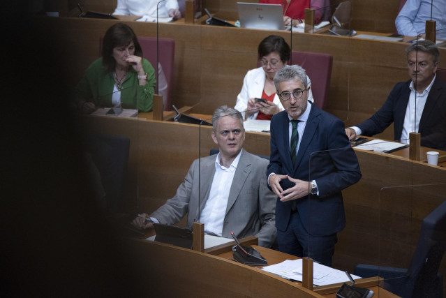 El conseller de Hacienda, Arcadi España (d), interviene durante un pleno de Les Corts